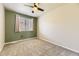 Bright bedroom with plush carpeting, modern ceiling fan, and large window at 11302 Tumbleweed Way, Parker, CO 80138