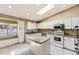 Well-lit kitchen with white cabinetry, granite countertops, stainless appliances, and skylight at 11302 Tumbleweed Way, Parker, CO 80138