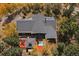 Aerial view of the property featuring a gray roof, deck, hot tub and mature trees at 239 Aspen Pl, Evergreen, CO 80439