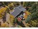 Aerial view of home with gray roof surrounded by trees, featuring a deck and hot tub at 239 Aspen Pl, Evergreen, CO 80439