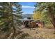 Private backyard featuring an outdoor kitchen, dining area, and lush landscaping, ideal for entertaining and relaxation at 239 Aspen Pl, Evergreen, CO 80439