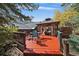 Backyard deck featuring outdoor dining, a hot tub, and views of the surrounding natural landscape at 239 Aspen Pl, Evergreen, CO 80439