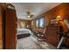 Cozy bedroom featuring wood paneled walls, ceiling fan and a dresser, creating a relaxing retreat at 239 Aspen Pl, Evergreen, CO 80439