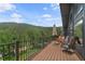 Relax on this mountain view deck with wood railings and chairs for outdoor enjoyment at 239 Aspen Pl, Evergreen, CO 80439