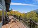 Mountain views from this rustic home's wood deck with railing and seating area at 239 Aspen Pl, Evergreen, CO 80439