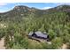Stunning exterior of a mountain home with a deck surrounded by lush trees at 239 Aspen Pl, Evergreen, CO 80439