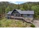 Beautiful mountain home features a deck, stone accents, and lush landscaping, perfect for enjoying the outdoors at 239 Aspen Pl, Evergreen, CO 80439