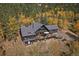 View of a stunning single-Gathering home with a sprawling wooden deck set among dense forest at 239 Aspen Pl, Evergreen, CO 80439