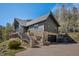 View of a modern mountain home with stone accents, a spacious deck, and a well-maintained yard at 239 Aspen Pl, Evergreen, CO 80439