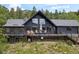Exterior of home showcasing large windows, black siding, and deck with furniture at 239 Aspen Pl, Evergreen, CO 80439