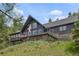 Exterior view of a multi-level home featuring a deck and mature trees at 239 Aspen Pl, Evergreen, CO 80439