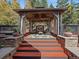 Outdoor gazebo with a fireplace, comfortable seating, and elegant curtains, creating a cozy outdoor retreat at 239 Aspen Pl, Evergreen, CO 80439