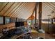 Cozy home office featuring wood-paneled walls, slanted ceilings, and a desk with a view of the natural landscape at 239 Aspen Pl, Evergreen, CO 80439