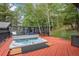 Relaxing hot tub on a wooden deck with a privacy screen and wooded surroundings at 239 Aspen Pl, Evergreen, CO 80439