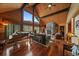 Inviting living room with vaulted ceilings, stone fireplace, piano and large windows overlooking mountain views at 239 Aspen Pl, Evergreen, CO 80439