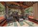 Cozy outdoor living space with fireplace, comfortable seating, ceiling fan, and decorative ceiling at 239 Aspen Pl, Evergreen, CO 80439