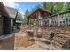 Stone patio with outdoor fireplace, chairs, and gazebo perfect for entertaining and relaxing at 239 Aspen Pl, Evergreen, CO 80439