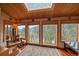 Bright sitting area with wood paneled walls and ceilings, large windows and comfortable seating at 239 Aspen Pl, Evergreen, CO 80439
