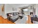 Bright living room features wood flooring, fireplace, large leather sofa, and sliding door to patio at 9538 W San Juan Cir # 104, Littleton, CO 80128