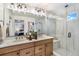 Bathroom featuring double sinks, decorative mirror, walk in shower, and artwork at 2036 S Holly St # 1, Denver, CO 80222