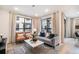 Comfortable living room featuring a stylish gray sofa, brown leather chairs, and large windows at 2036 S Holly St # 1, Denver, CO 80222