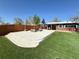 Landscaped backyard featuring a concrete patio, artificial turf, and a charming outdoor seating area, perfect for relaxation at 8590 Faraday St, Denver, CO 80229