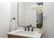 Modern bathroom featuring a sleek vanity, matte black fixtures, and elegant white orchid centerpiece at 7830 Ladore St, Commerce City, CO 80022