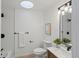 Bright bathroom featuring a skylight, tiled shower, toilet, and vanity with modern fixtures at 7830 Ladore St, Commerce City, CO 80022