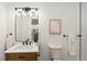 This bathroom is updated with modern fixtures including a vessel sink, a framed mirror and black hardware accents at 7830 Ladore St, Commerce City, CO 80022