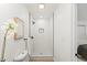 Bright bathroom featuring tiled walk-in shower with modern fixtures, with the toilet and bedroom visible at 7830 Ladore St, Commerce City, CO 80022