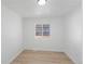 Bright, empty bedroom featuring wood floors, a large window, and white walls at 7830 Ladore St, Commerce City, CO 80022