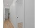 Hallway featuring wood floors and white walls, with doorways leading to other rooms in the house at 7830 Ladore St, Commerce City, CO 80022