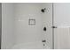 This clean shower features white subway tile, sleek black hardware, and a built-in niche for added convenience at 7830 Ladore St, Commerce City, CO 80022