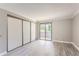 Bedroom featuring light gray wood floors, sliding closet doors, and sliding glass doors to a balcony at 9837 E Peakview Ave # 7, Englewood, CO 80111