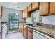 Kitchen featuring wood cabinets, granite countertops, a double sink, and a window view of the outdoors at 9837 E Peakview Ave # 7, Englewood, CO 80111