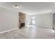 Spacious living room with a stone fireplace, light gray wood floors, and a bright window at 9837 E Peakview Ave # 7, Englewood, CO 80111