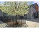 Exterior of gray building with a blooming tree in a fenced yard providing curb appeal at 117 Elati St # 1, Denver, CO 80223