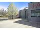 Exterior shot of a gray building with a well-maintained yard and lush white flowering tree at 117 Elati St # 1, Denver, CO 80223