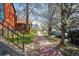 Cozy front yard with a brick path, rock garden, and mature trees lining the sidewalk at 117 Elati St # 1, Denver, CO 80223