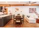 Open concept living room featuring modern decor, wood beams, exposed brick, and a dining table set at 117 Elati St # 1, Denver, CO 80223