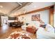 Open concept living room featuring modern decor, wood beams, concrete floors, and a stylish area rug at 117 Elati St # 1, Denver, CO 80223