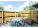 Private patio with a table, four chairs, garden, and wooden fence offers a charming outdoor dining experience at 117 Elati St # 1, Denver, CO 80223