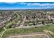 Scenic aerial view of a neighborhood showcasing homes, streets, mature trees, and a sprawling park on a clear day at 6773 E Baker Pl, Denver, CO 80224