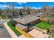 Property showcasing a fenced backyard, outdoor deck, mature trees, and a well-maintained lawn on a bright day at 6773 E Baker Pl, Denver, CO 80224