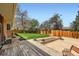 Green backyard with a grassy area, a wooden deck, and a wooden fence, perfect for outdoor enjoyment at 6773 E Baker Pl, Denver, CO 80224
