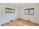 Empty bedroom with hardwood floors, baseboard heaters, and two windows that provide natural light at 6773 E Baker Pl, Denver, CO 80224
