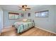A bedroom with hardwood floors, two windows, ceiling fan, and light blue paint at 6773 E Baker Pl, Denver, CO 80224