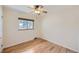 Empty bedroom with hardwood floors, baseboard heaters, one window and a ceiling fan with light at 6773 E Baker Pl, Denver, CO 80224