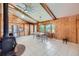 Open dining area features wood paneled walls, vaulted ceilings, tile flooring, and many windows for natural light at 6773 E Baker Pl, Denver, CO 80224