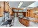 Large kitchen featuring wooden cabinets, marble countertops, skylights, and an island with stove at 6773 E Baker Pl, Denver, CO 80224